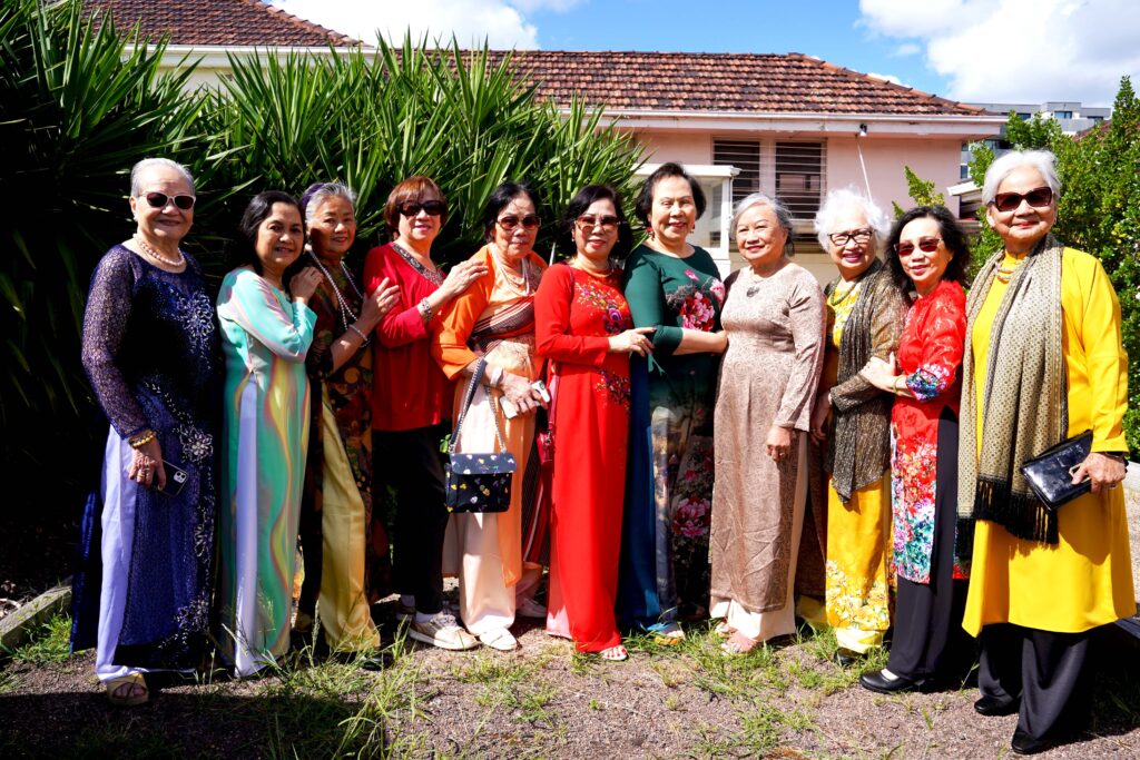 A group of elderly Vietnamese women standing in the garden at Spectrum's Clifton Respite Cottage in Preston. They are gathering to celebrate Lunar New Year.